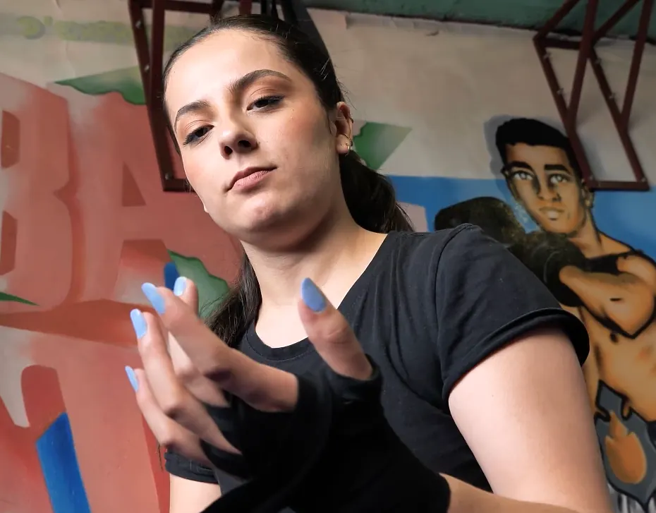Jeune femme en t-shirt noir devant une fresque murale colorée