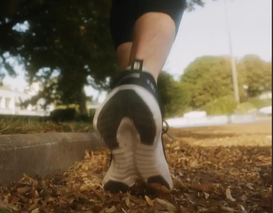 Gros plan d’une chaussure de running dans les feuilles mortes