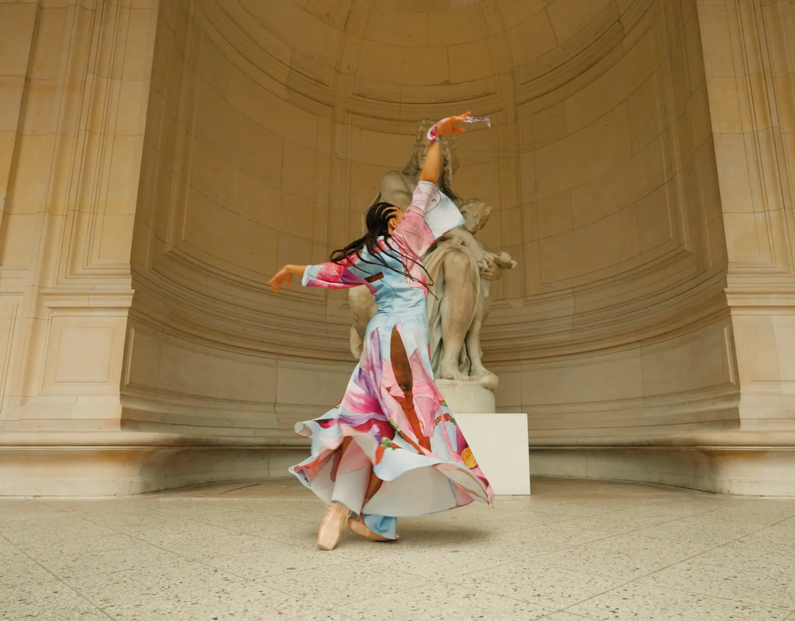 Danseuse en robe colorée tournoyant sous une voûte de pierre