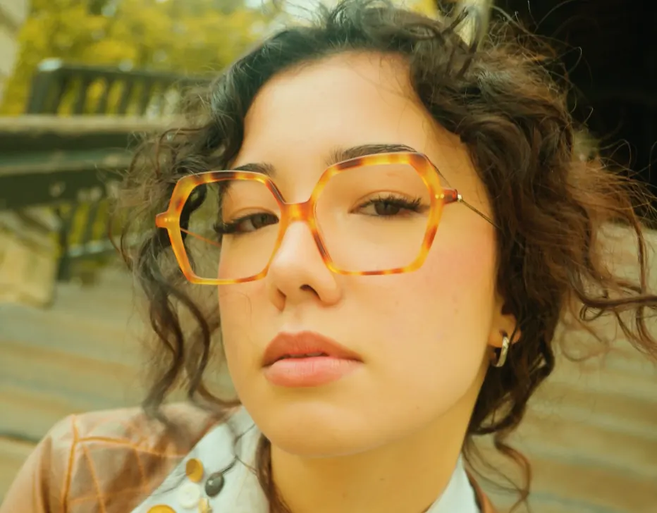 Portrait rapproché d’une femme aux lunettes écaille et aux cheveux bouclés